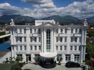 a large white building with a car parked in front at Hotel Britania in Tirana