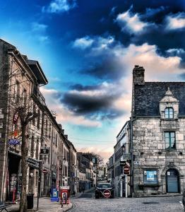 an old city street with cars parked on the street at Hotel les voyageurs in Saint-Renan
