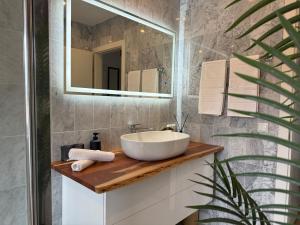 a bathroom with a sink and a mirror at Penthouse Panorama Seeblick in Gmunden +17 photos