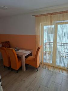 a dining room with a table and chairs and a window at Stan na dan Emili 2 in Valjevo