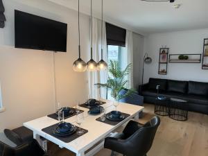 a living room with a white table and chairs at Penthouse Panorama Seeblick in Gmunden