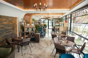 a restaurant with tables and chairs and windows at Hotel Britania in Tirana