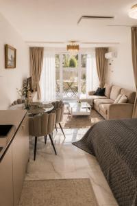 a kitchen and living room with a bed and a table at Maluno vilos apartamentas su terasa in Palanga