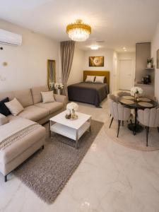 a living room with a couch and a bed at Maluno vilos apartamentas su terasa in Palanga +6 photos