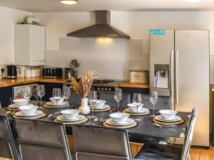 a kitchen with a table with chairs and a refrigerator at Summerleaze House in Bude