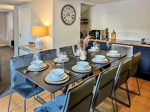 a dining room with a table with chairs and a clock at Summerleaze House in Bude