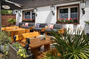 eine Terrasse mit Sofas, Tischen und Blumen in der Unterkunft Gasthof Sonnental in Winterberg