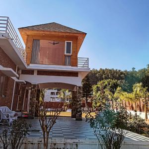 a house with a balcony and a patio at Tranquil Nature Resort in Rāipur