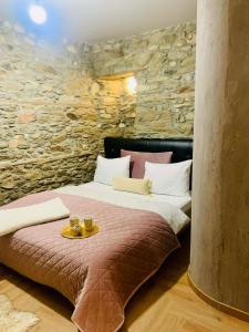 a bedroom with a bed and a stone wall at Βίλα Βασιλική in Elassona