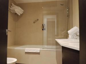 a bathroom with a shower and a tub and a sink at Hotel Rey Sancho in Navarrete +65 photos