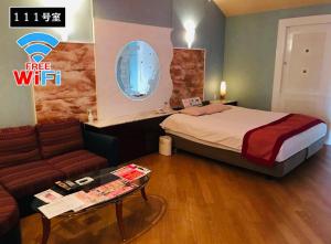 a hotel room with a bed and a couch at バリアンリゾート山口BarianResort Yamaguchi in Sanyoonoda