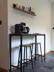 a table with two stools and a coffee maker at La Cour d'Enchère in Saint-Palais