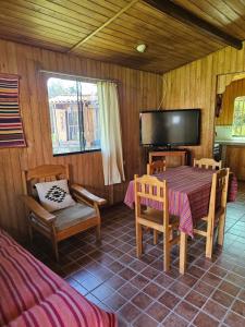 a dining room with a table and chairs and a television at Apu Ecolodge in Caraz