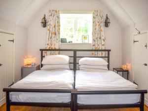 two beds in a room with a window at Serendipity in Molland
