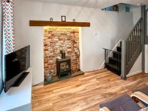 a living room with a fireplace and a tv at Serendipity in Molland