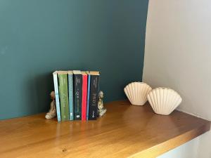 a row of books on a shelf with two vases at Βίλα Βασιλική in Elassona