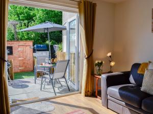 a living room with a couch and a table with an umbrella at Little Cottage in Wigtown