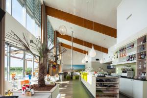 a restaurant with a palm tree in the middle of a room at Vakantiepark de Boomgaard in Westkapelle