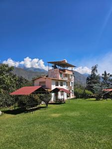 a large building in a field with a grass yard at Apu Ecolodge in Caraz