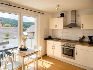 a kitchen and dining room with a table and a window at Gemütliches Apartment 8 am Titisee mit Balkon, Top Lage, Parkplatz in Titisee-Neustadt