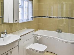 a bathroom with a sink and a tub and a toilet at Gwelmor in Charlestown