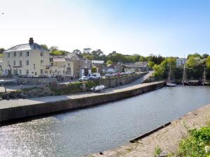 a river with boats in the middle of a town at Gwelmor in Charlestown +2 photos