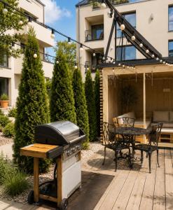 a backyard with a grill and a picnic table at Maluno vilos apartamentas su terasa in Palanga