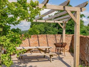 a wooden pergola with a bench and a barrel at Cleugh Foot in Longtown