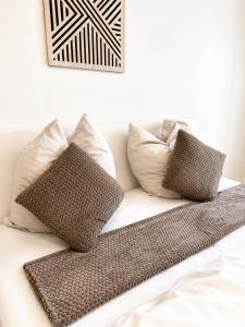 a white couch with pillows and a blanket on it at Gemütliches Apartment 8 am Titisee mit Balkon, Top Lage, Parkplatz in Titisee-Neustadt