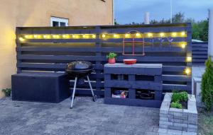 a barbecue grill with lights on a fence at 2 Bedroom Lovely Apartment In Gørlev in Gørlev +7 photos