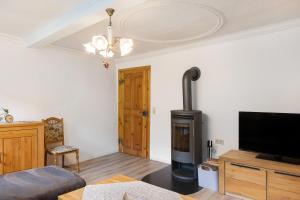 a living room with a fireplace and a flat screen tv at Ferienwohnung Stadthaus in Mellrichstadt