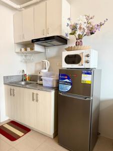 a kitchen with a stainless steel refrigerator and a microwave at La Casa Del Comienzo- Plumera Mactan Near Airport in Lapu Lapu City +28 photos