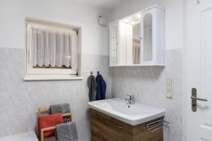 a bathroom with a sink and a mirror at Ferienwohnung Stadthaus in Mellrichstadt +20 photos