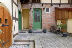 a green door on the side of a brick building at Ferienwohnung Stadthaus in Mellrichstadt