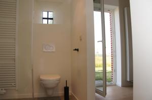a bathroom with a toilet and a window at Vakantiewoning Hof ter Heidje in Maarkedal