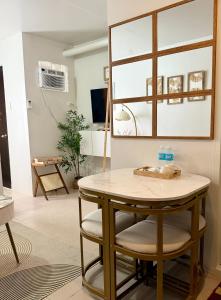 a table and two chairs in a room with a mirror at La Casa Del Comienzo- Plumera Mactan Near Airport in Lapu Lapu City