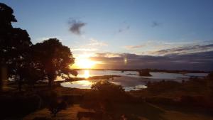 a sunset over a river with the sun setting at Corrib View Country House in Killarone