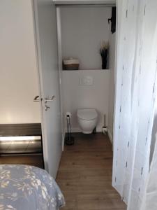 a small bathroom with a toilet and a bed at Une pause au pied des Pyrénées in Asson +4 photos
