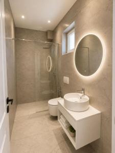 a bathroom with a sink and a toilet and a mirror at Vila Beqja in Durrës