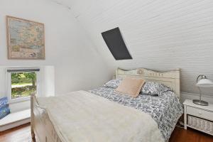 a bedroom with a bed and a lamp and a window at Gîte La P'tite Longère in Saint-Jacut-les-Pins