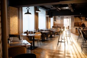 a dining room with tables and chairs and windows at Hotel Park in Široki Brijeg