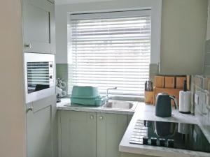 a kitchen with a sink and a window at New Meadows Cottage in Pickering +3 photos