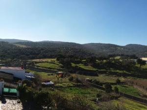 una vista de una granja con montañas en el fondo en Virgen De Los Remedios, en Arroyomolinos de León