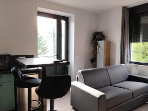 a living room with a couch and a table and chairs at Une pause au pied des Pyrénées in Asson