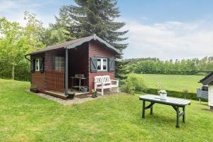 a small cabin with a table in the grass at Ferienwohnung Sunnenviul in Lennestadt
