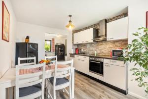 a kitchen with white cabinets and a table and chairs at Ferienwohnung Sunnenviul in Lennestadt