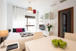 Un dormitorio con una cama y una mesa con fruta. en Colón12 Urban Apartment, en Málaga