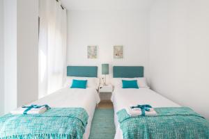 マラガにあるColón12 Urban Apartmentのベッド2台(ビーチサンダル付)が備わる客室です。