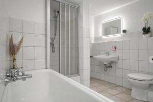 ein Badezimmer mit Badewanne, Toilette und Waschbecken in der Unterkunft Gasthof Sonnental in Winterberg + 47 Fotos