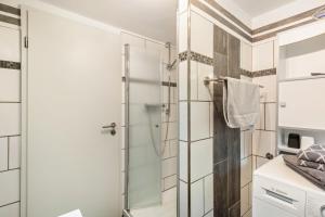 a bathroom with a shower with a glass door at Ferienwohnung Sunnenviul in Lennestadt +10 photos